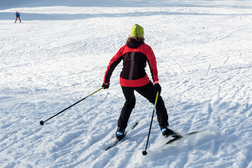 view of young woman riding cross-country skiing