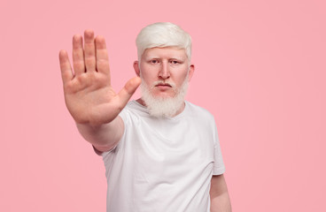 Albino man gesturing stop to camera