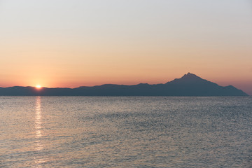 Wonderful sunrise view behind the mountains and next to the sea