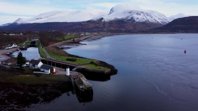aerial drone footage of coal near fort william showing loch eil and ben nevis in the argyll region of the highlands of scotland on a winter day with blue sky and snow capped mountains