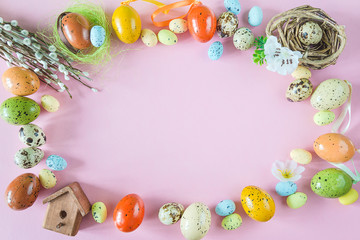 Naklejka na ściany i meble Beautiful easter holiday background. Frame of multicolored eggs, nest, birdhouse and willow twigs on pink background. Space for text