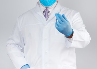 doctor in a white coat and tie, wearing blue sterile gloves on his hands