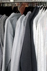Strickjacken, Shirts und Pullover auf Kleiderbügeln