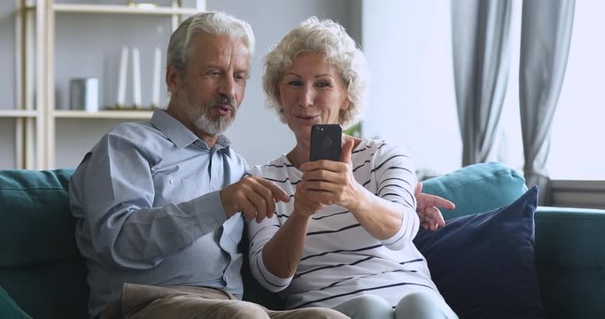 Happy middle aged family having fun, making selfie on smartphone.