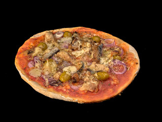 Pizza with sardines, tomatoes and olives on a thin dough.On black background