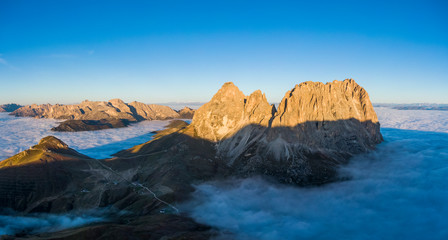 Fototapeta na wymiar Aerial panorama of cloud sea at Sella mountain pass between the provinces of Trentino and South Tyrol, Dolomites