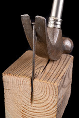 Pulling out a nail with a carpenter's hammer. Carpentry accessories on a workshop table.