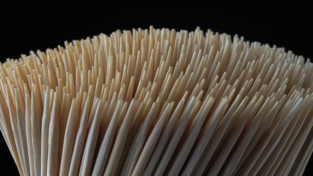 Wooden toothpicks or cocktail sticks extreme close up. Hand picks made of bamboo macro shoot of rotation. Concept of teeth hygiene or oral tooth care. Caries prevention. Dental healthcare.