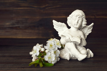 Angel and spring flowers on dark background