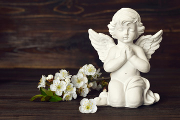 Guardian angel and spring flowers on dark background