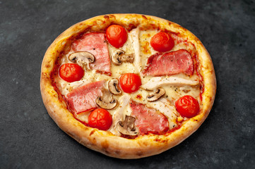  meat pizza with cheese, chicken, ham, champion mushrooms, tomatoes on a stone background