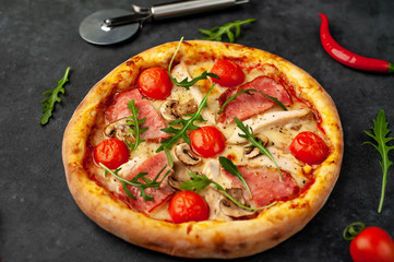  meat pizza with cheese, chicken, ham, champion mushrooms, tomatoes on a stone background