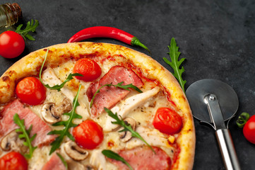 meat pizza with cheese, chicken, ham, mushrooms, tomatoes on a stone background with copy space for your text