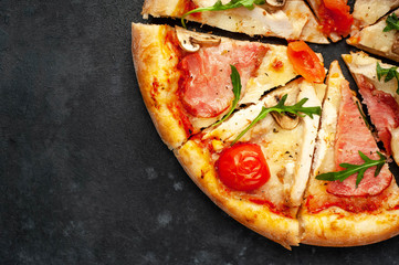 meat pizza with cheese, chicken, ham, mushrooms, tomatoes on a stone background with copy space for your text