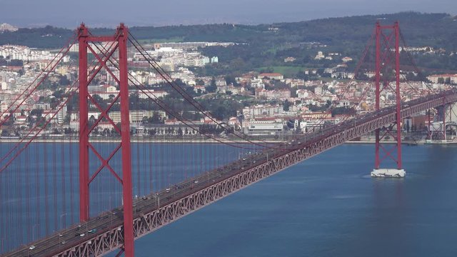 The Bridge of 25th April with car traffic and panoramic view of the city on the background, Lisbon, Portugal, 4k