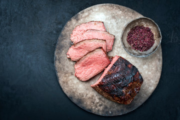 Traditional Commonwealth Sunday roast with sliced cold cuts roast beef with red salt as top view on...