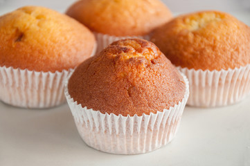 Fresh homemade delicious muffins are taken out of the oven and they cool on the kitchen table. Sweet dessert.