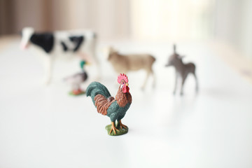 Group of realistic figures of farm animals standing on a shelf