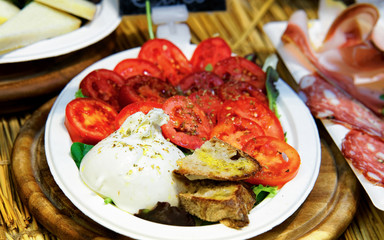 Traditional Italian platter with tomato burata bread and bacon