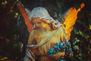 Guardian angel. Ancient statue in the light.