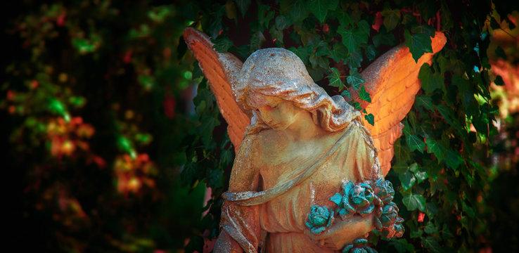 Beautiful sad angel. Vintage styled image of ancient statue.