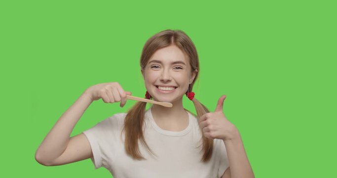woman smiling and showing eco-friendly toothbrush