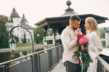 Cute couple in a park. Lady in a white dress. Guy in a white shirt.