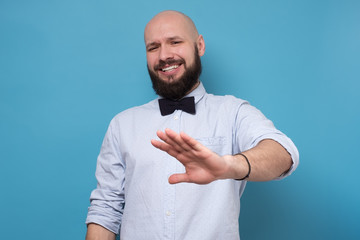 Handsome bearded man making stop sign refusing to drink alcohol on party.