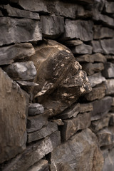 pattern gray color of modern style design decorative uneven cracked real stone wall surface with cement.Stone wall for background. Stone wall texture. Part of a stone wall, for background or texture