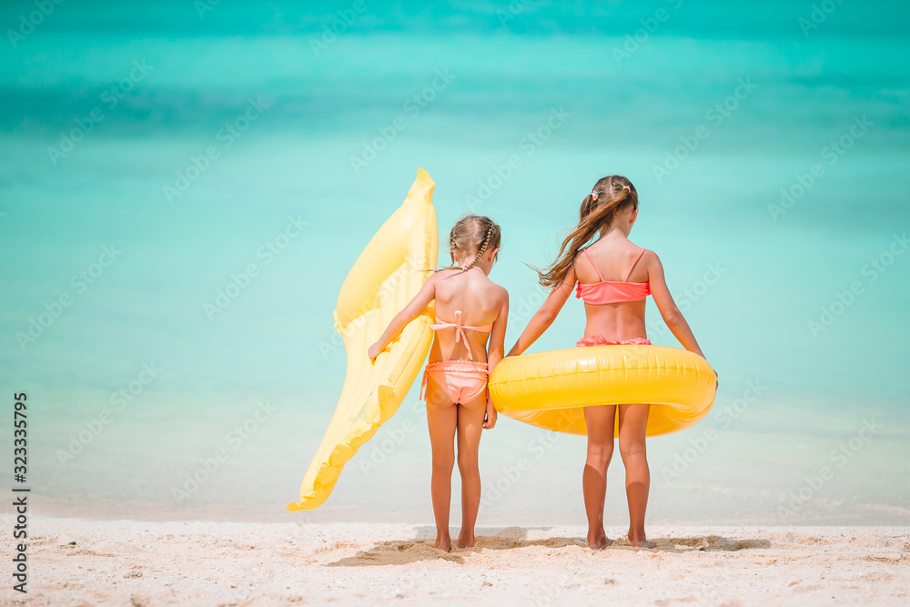 Wall mural little happy funny girls have a lot of fun at tropical beach playing together. sunny day with rain i