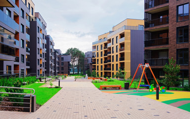 Fototapeta na wymiar Children playground with European modern residential buildings quarter