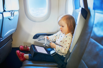 Adorable little toddler girl traveling by plane