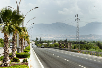 Straight road background with cloudy sky.