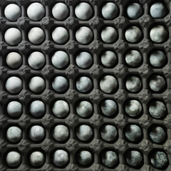 Colored easter quail eggs in open cardboard packing, pattern, top view