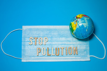 Text STOP POLUTION and protective medical mask on blue background. Virus Pandemic Protection Concept. 2019 nCoV virus infection. outbreak continues to spread outside China. Coronavirus