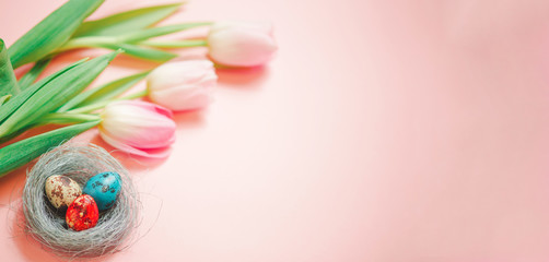 Pink tulips and easter eggs on pink background