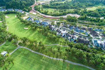 Fototapeta na wymiar Aerial view drone Top down shot of beautiful green golf field with modern villa High angle view in summer time.