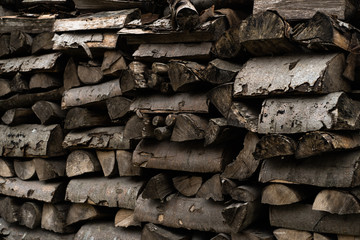 Wooden background. Firewood stack for the background. A lot of cutted logs. Stack of sawn logs. Natural wooden decor background. Pile of chopped fire wood prepared for winter.