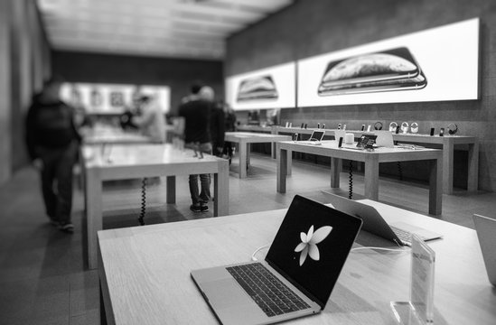 PARIS, FRANCE - OCT 25, 2018: Apple Computers Store with customers inside admiring iPhone Xs XR smartphones - shopping for latest electronics black and white image