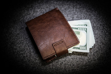 Stylish men's purse with money on wood background.