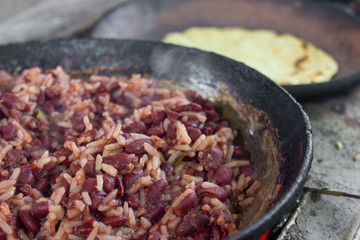 cooking traditional Nicaraguan food known as gallo pinto and tortillas on a wood fire