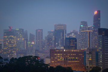 Fototapeta na wymiar Blurry city scape of public housing in central Singapore, light bokeh during blue hour