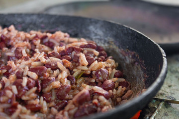cooking traditional Nicaraguan food known as gallo pinto and tortillas on a wood fire
