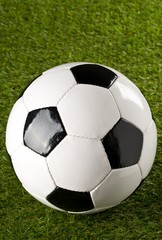Fototapeta premium Single soccer ball on green grass lawn background with copy space