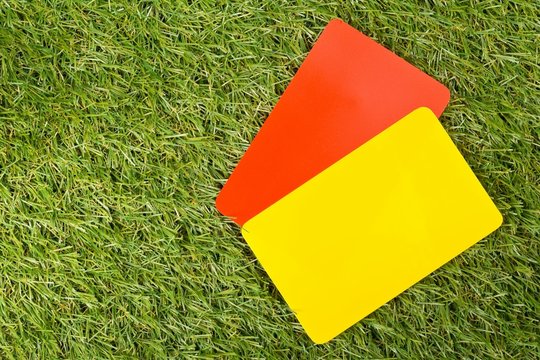 Soccer sports referee yellow and red cards on grass background flat lay from above