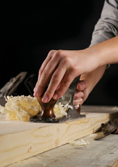 Joinery. Planing a natural wood furniture panel with a manual planer
