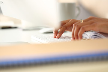 Hand of black woman type something with white wireless computer keyboard closeup