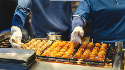 Asian man cooking takoyaki ball on hot pan famous food japan street food.;
