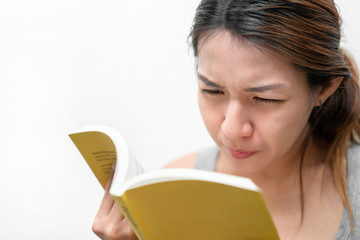 Asian woman reading book, has bad vision sight problems, selective focus, myopia and eyesight problem concept.