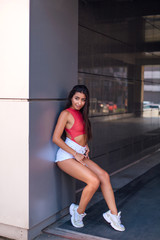 Young brunette woman standing in arch of building.